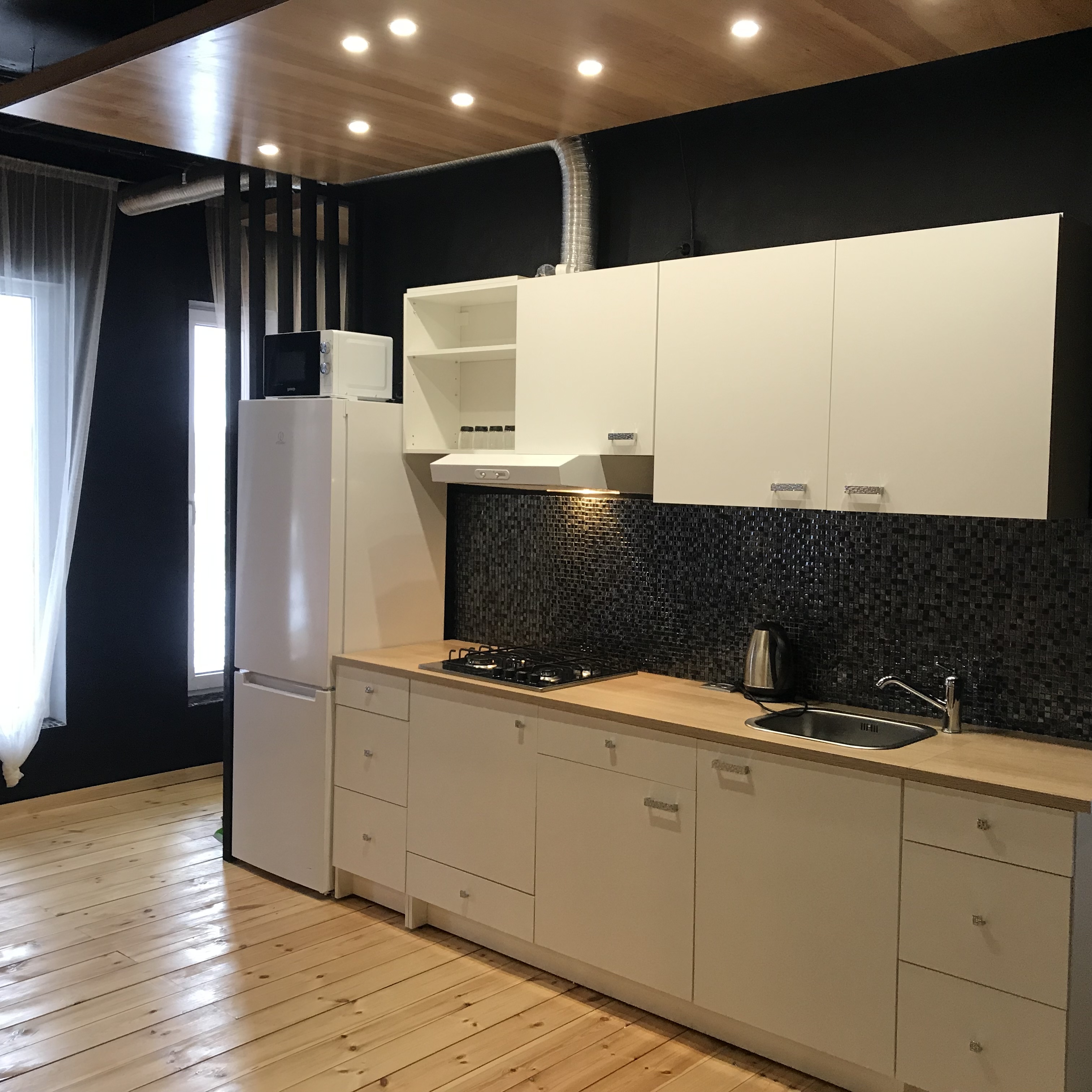 Kitchen with marble countertops and dark green cabinetry